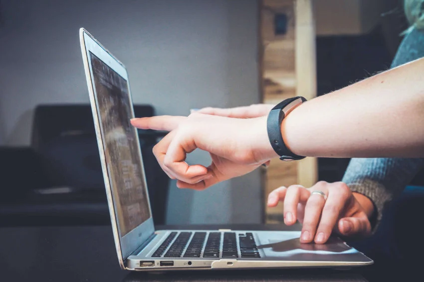 People pointing at a laptop screen